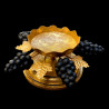 Gilded candle holder and black grapes